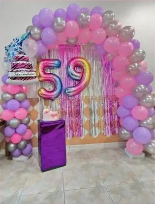 Arco de globos rosas, lilas y plateados con números de colores
