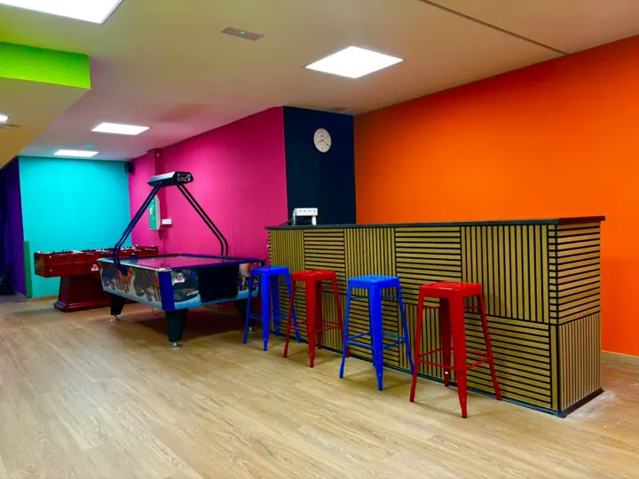 Barra con taburetes de colores y air hockey