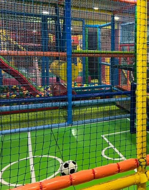 Tobogán que cae a la piscina de bolas, junto a la pista de fútbol